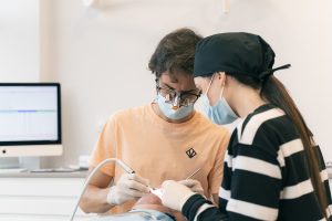Odontólogo realizando una endodoncia junto a una auxiliar